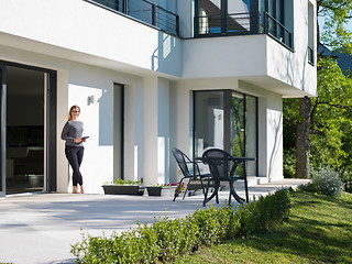 Image showing women using tablet computer in front of luxury home villa