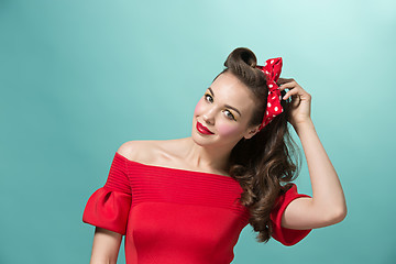 Image showing Beautiful young woman with pinup make-up and hairstyle. Studio shot on white background