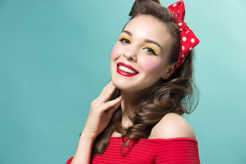 Image showing Beautiful young woman with pinup make-up and hairstyle. Studio shot on white background