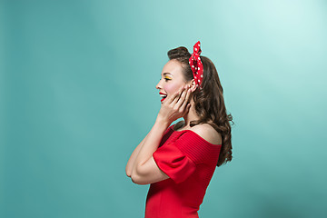 Image showing Beautiful young woman with pinup make-up and hairstyle. Studio shot on pastel background