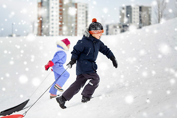 Image showing kids with sleds climbing snow hill in winter