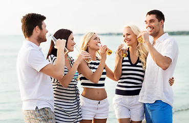 Image showing happy friends drinking non alcoholic beer on beach