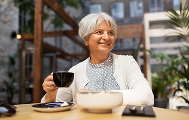 Image showing senior woman drinking coffee at street cafe