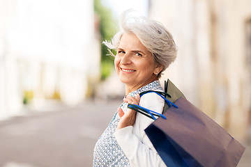 Image showing senior woman with shopping bags in city