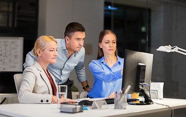 Image showing business team with computer working late at office