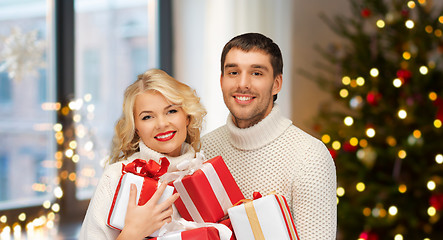 Image showing happy couple with christmas gifts at home