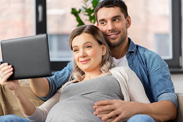 Image showing man and pregnant woman with tablet pc at home