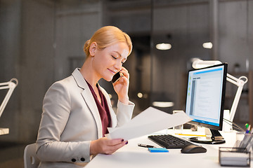 Image showing businesswoman calling on smartphone at office