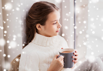 Image showing girl in winter sweater with cacao mug at window