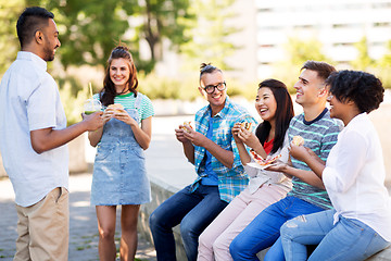 Image showing friends eating pizza and sandwiches in park