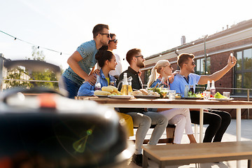 Image showing happy friends taking selfie at rooftop party