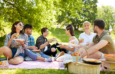 Image showing happy friends eating sandwiches at summer picnic