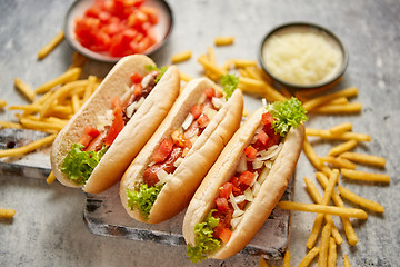 Image showing Assortment of three tasety hot dogs, placed on wooden cutting board