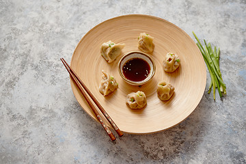 Image showing Delicious chinese dumplings served on wooden plate