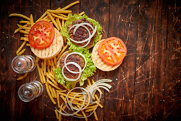 Image showing Two tasty grilled home made burgers with beef, tomato, onion and lettuce