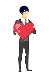 Image showing Asian groom holding a big red heart.