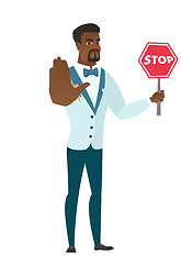 Image showing African-american groom holding stop road sign.