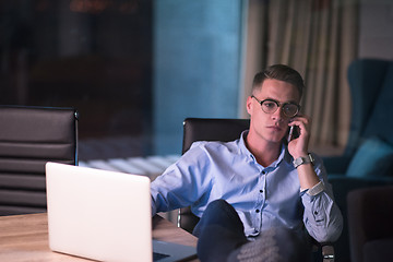 Image showing businessman using mobile phone in dark office