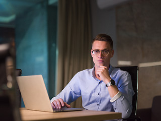 Image showing man working on laptop in dark office