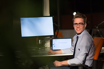 Image showing man working on computer in dark office