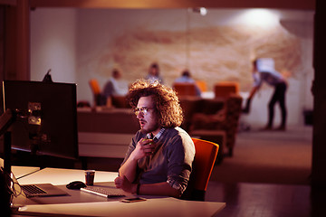 Image showing man working on computer in dark office