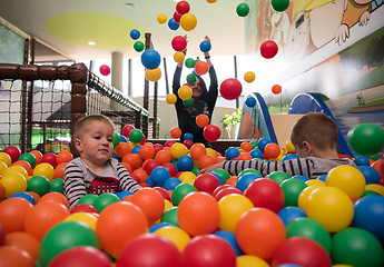 Image showing Young mom with her kids in a children\'s playroom