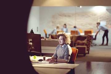 Image showing man working on computer in dark office