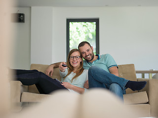 Image showing Young couple on the sofa watching television