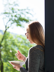 Image showing woman eating breakfast in front of her luxury home villa