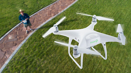 Image showing Drone Quadcopter (UAV) In Air Above Pilot With Remote Controller