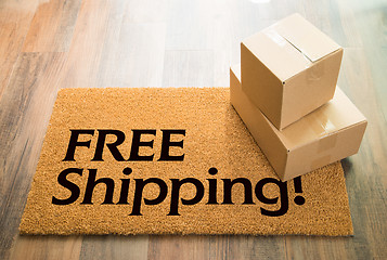 Image showing Free Shipping Welcome Mat On Wood Floor With Shipment of Boxes