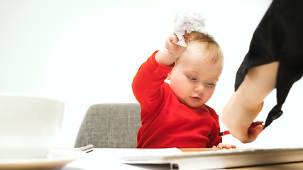 Image showing Happy child baby girl toddler sitting with keyboard of computer isolated on a white background