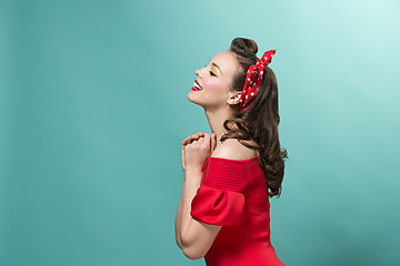 Image showing Beautiful young woman with pinup make-up and hairstyle. Studio shot on pastel background