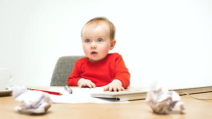 Image showing Happy child baby girl toddler sitting with keyboard of computer isolated on a white background