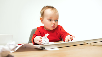 Image showing Happy child baby girl toddler sitting with keyboard of computer isolated on a white background