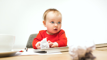 Image showing Happy child baby girl toddler sitting with keyboard of computer isolated on a white background