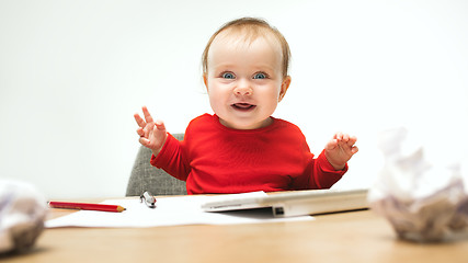 Image showing Happy child baby girl toddler sitting with keyboard of computer isolated on a white background