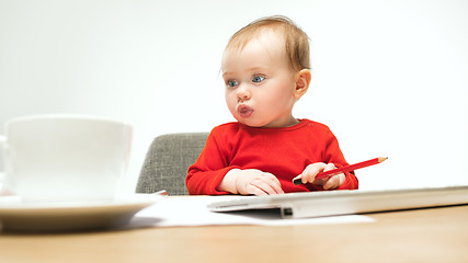 Image showing Happy child baby girl toddler sitting with keyboard of computer isolated on a white background