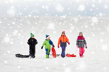 Image showing happy little kids with sleds sledging in winter