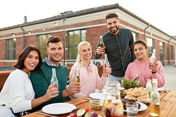 Image showing happy friends with drinks or bbq party on rooftop