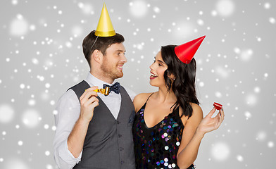 Image showing happy couple with party blowers having fun