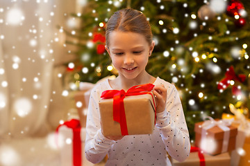 Image showing smiling girl with christmas gift at home