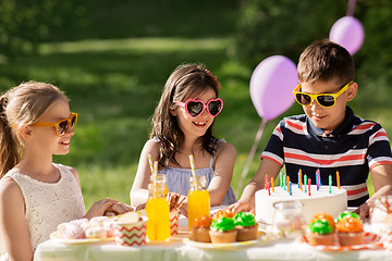 Image showing happy kids with cake on birthday party at summer