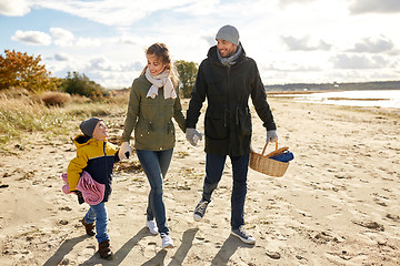 Image showing happy family going to picnic on beach in autumn