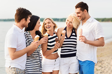 Image showing happy friends eating ice cream on beach