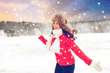 Image showing happy woman in fur hat over winter background