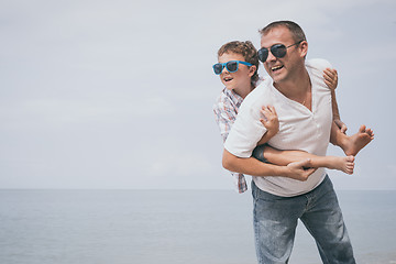 Image showing Father and son playing on the beach at the day time.