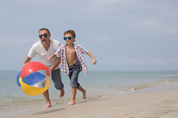 Image showing Father and son playing on the beach at the day time.