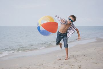 Image showing One happy little boy playing on the beach at the day time.