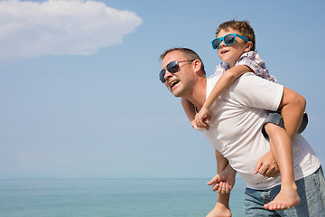 Image showing Father and son playing on the beach at the day time.